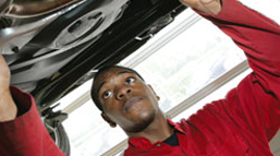 Apprentice working under car